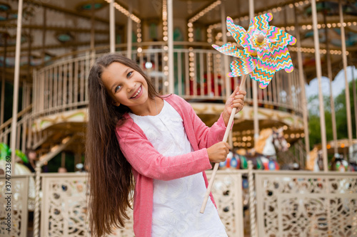 Cute teen girl plays near carousel in toy breeze © КРИСТИНА Игумнова