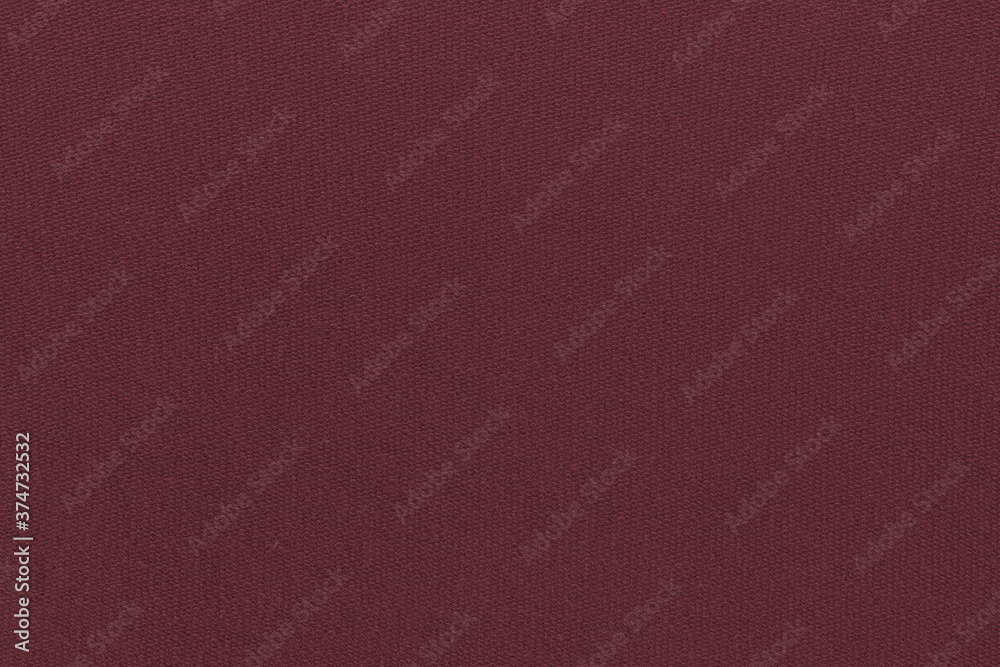 The texture of a simple knitted cotton fabric on the wrong side with a clear interweaving of maroon threads. Coarse plain cloth, burlap. The texture of a simple knitted cotton fabric on the wrong side with a clear interweaving of maroon threads. Coarse plain cloth, burlap.