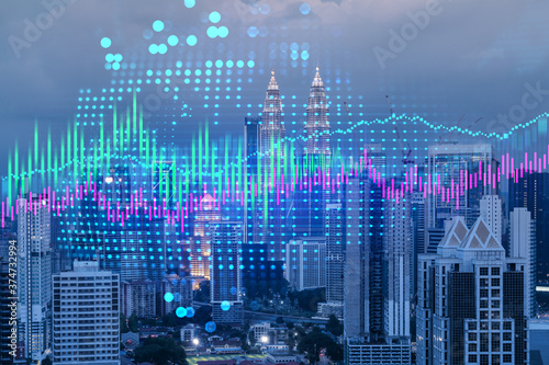 Stock market graph hologram  night panorama city view of Kuala Lumpur. KL is popular location to gain financial education in Malaysia  Asia. The concept of international research. Double exposure.