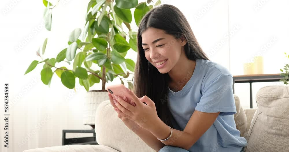 Smiling woman chatting using mobile phone at home Smiling woman chatting using mobile phone at home