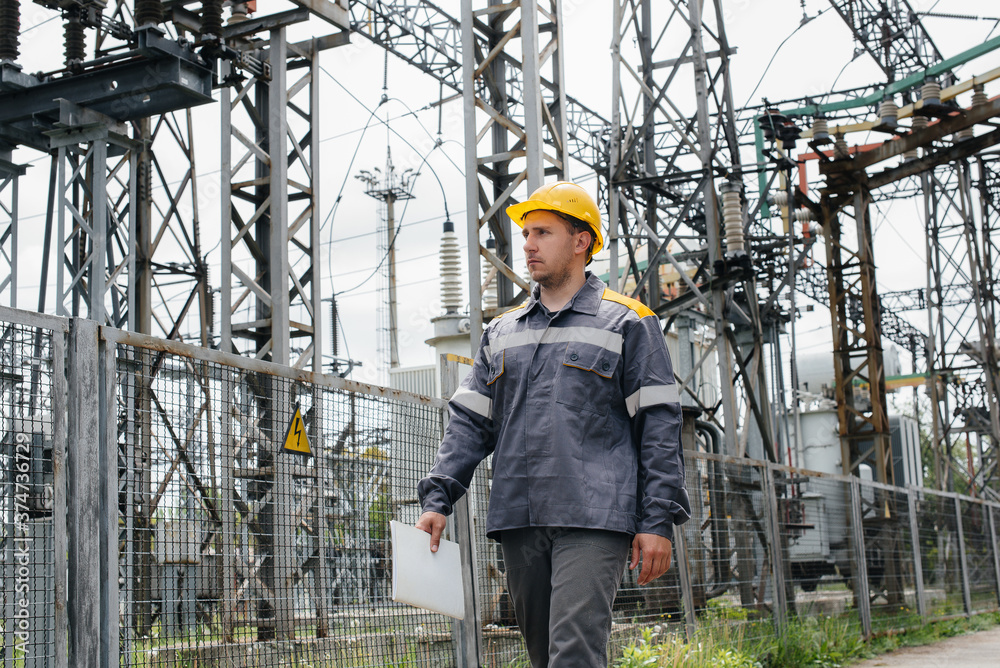 An engineering employee makes a tour and inspection of a modern electrical substation. Energy. Industry An engineering employee makes a tour and inspection of a modern electrical substation. Energy. Industry