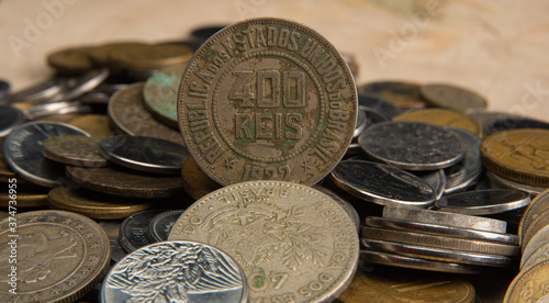 Old coins placed on a rustic wooden platform, selective focus
