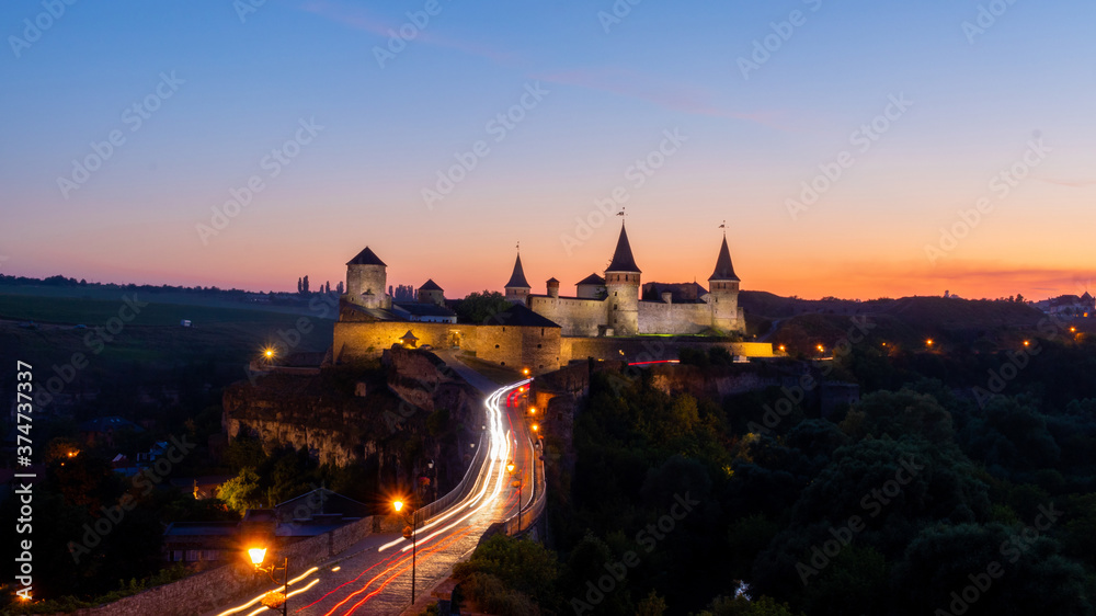Obraz premium Old castle. Sunset view of the castle in Kamyanets-Podilsky Ukraine. Castle photo on a postcard or cover