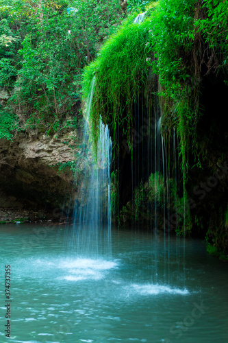 Jungle landscape with flowing turquoise water of a cascading waterfall. Burbun waterfall  Ukraine.