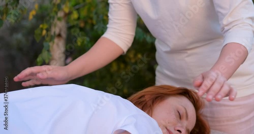 Woman do traditional chinese massage  outdoors in summer garden 