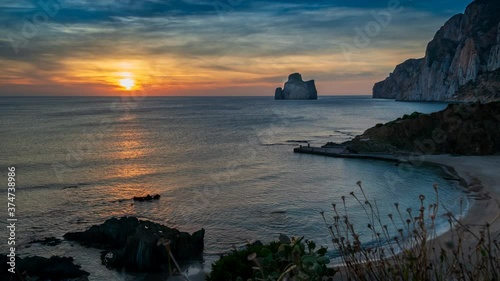 Timelapse at sunset in the suggestive setting of the Masua stream, overlooking the imposing rock of the Pan di Zucchero, along the Iglesiente coast in the southwest of Sardinia, Italy.