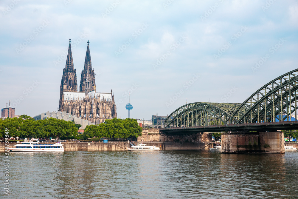 Cologne Cathedral and Hohenzollern Bridge over Rhine river on cloudy days