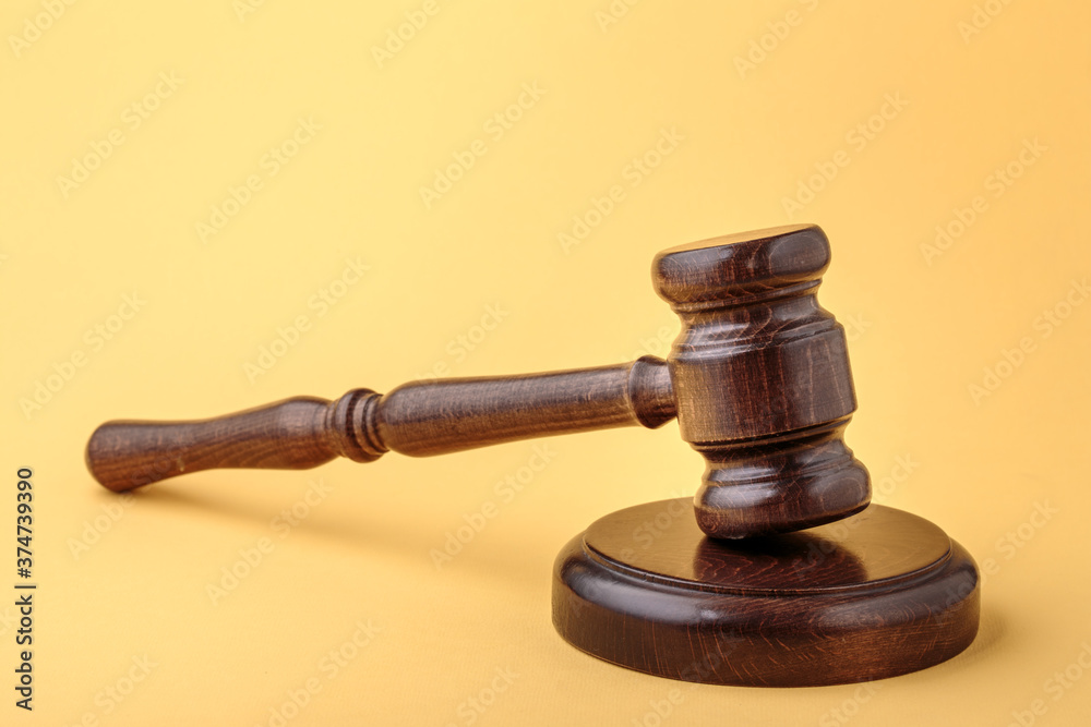 Judge gavel and soundboard on yellow background