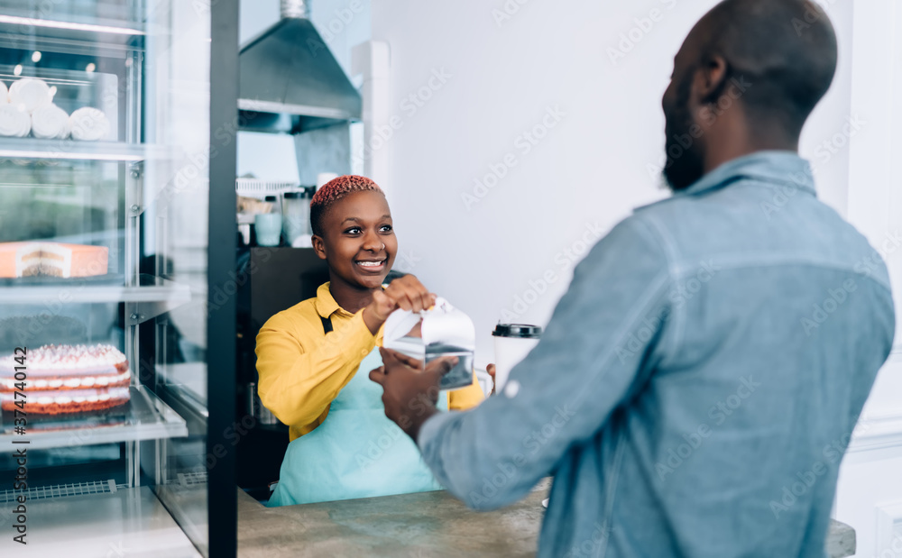 Joyful ethnic woman giving order client in cafe Joyful ethnic woman giving order client in cafe