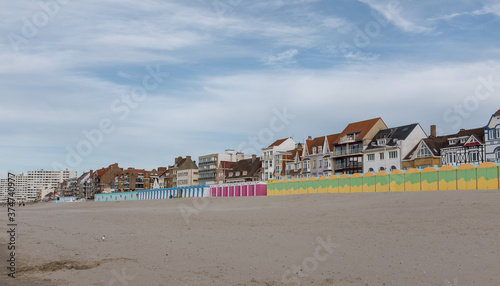 Bild auf Leinwand Colorful beach huts in front of historic seaside buildings in Dunkirk, France
