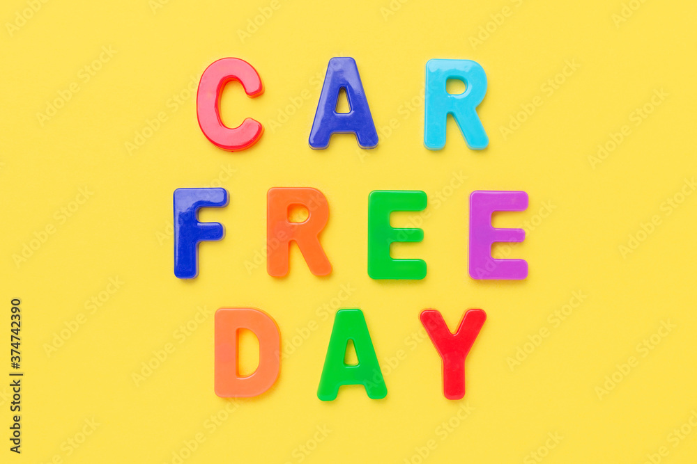 Multicolored text Car Free Day on yellow background. Concept of international car free day on September 22. Top view Multicolored text Car Free Day on yellow background. Concept of international car free day on September 22. Top view