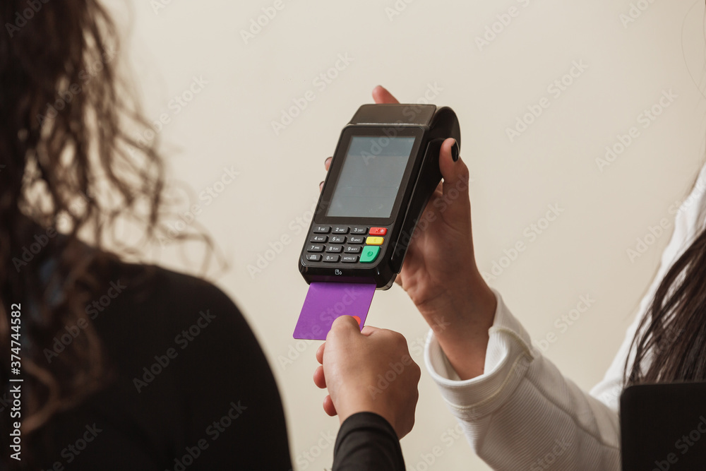 Woman at cash counter holding an electronic card payment machine. Woman at cash counter holding an electronic card payment machine.