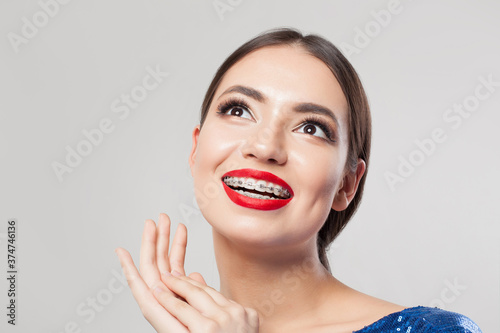 Portrait of happy woman with braces. Beautiful woman in braces smiling on white background