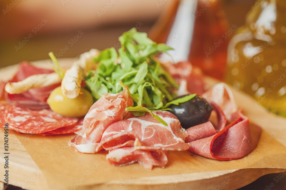Charcuterie board with prosciutto ham, salami, herbs and olive antipasti. Gourmet platters