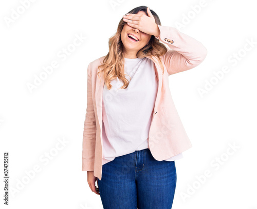 Young caucasian woman wearing business clothes smiling and laughing with hand on face covering eyes for surprise. blind concept. © Krakenimages.com
