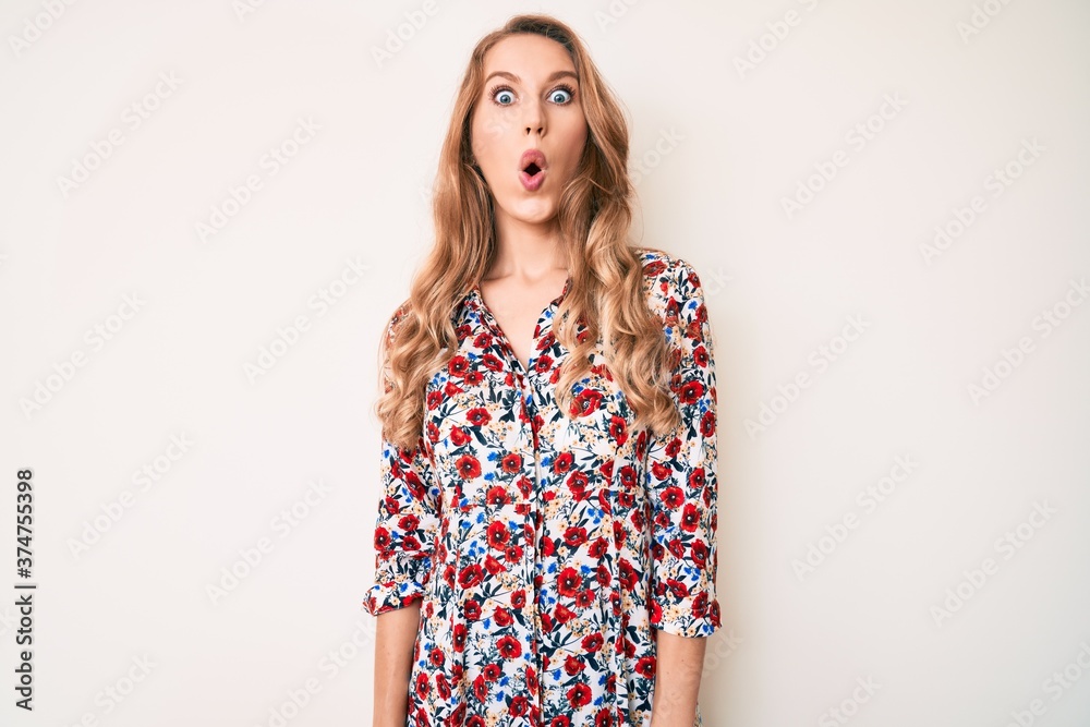 Young caucasian woman with blond hair wearing summer dress afraid and shocked with surprise expression, fear and excited face. Young caucasian woman with blond hair wearing summer dress afraid and shocked with surprise expression, fear and excited face.