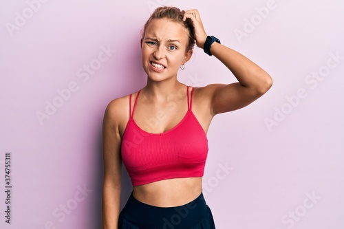 Beautiful caucasian woman wearing sportswear confuse and wonder about question. uncertain with doubt  thinking with hand on head. pensive concept.