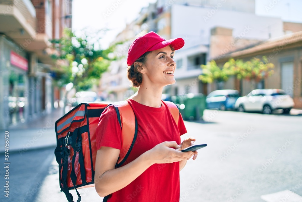 Delivery business worker woman wearing uniform and delivery bag smiling happy using phone Delivery business worker woman wearing uniform and delivery bag smiling happy using phone