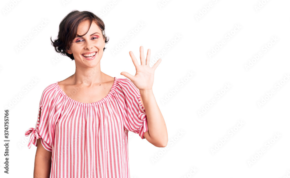 Beautiful young woman with short hair wearing casual summer clothes showing and pointing up with fingers number five while smiling confident and happy. Beautiful young woman with short hair wearing casual summer clothes showing and pointing up with fingers number five while smiling confident and happy.