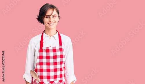 Beautiful young woman with short hair wearing professional cook apron with a happy and cool smile on face. lucky person.