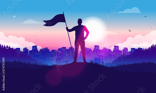Fotografia, Obraz Man with raised flag in front of city and sunlight - Proud male on hilltop