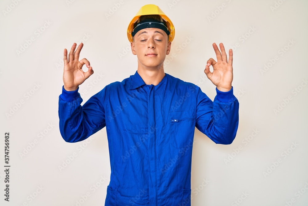 Young hispanic boy wearing worker uniform and hardhat relax and smiling with eyes closed doing meditation gesture with fingers. yoga concept.
