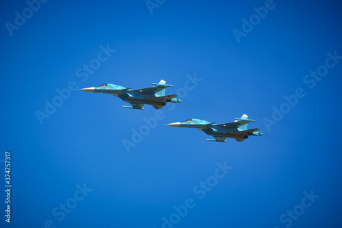 Two russian Su-34 Fullback fighter-bombers flying on the clean sky background