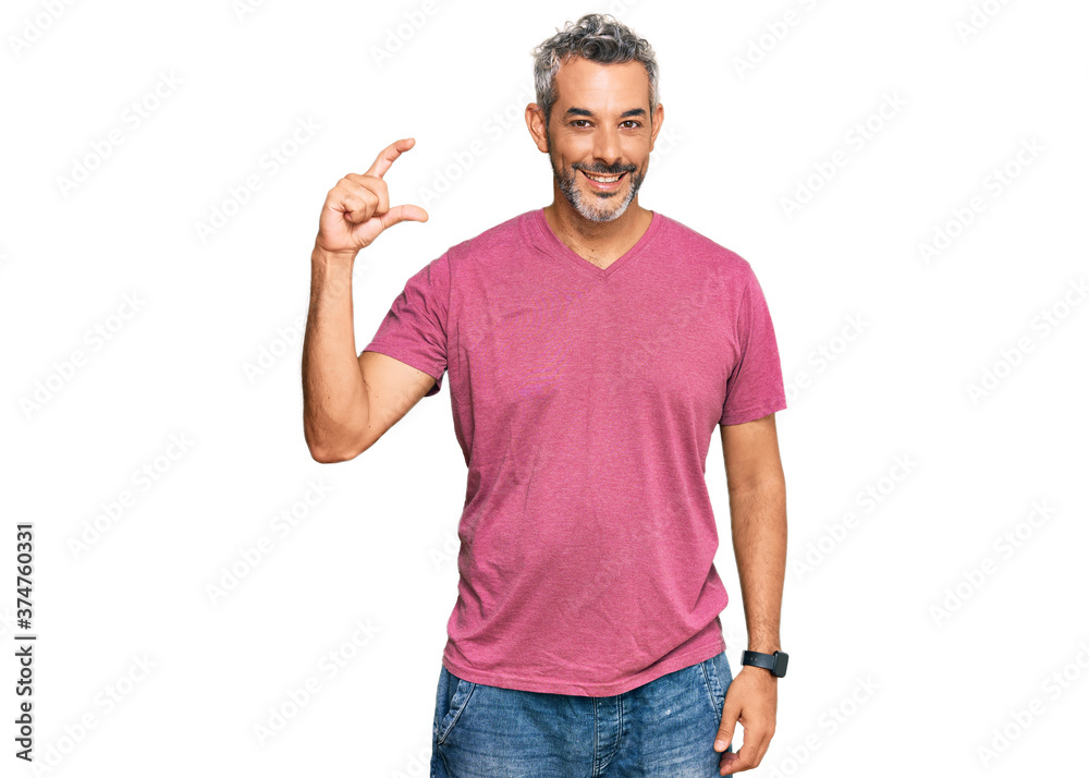 Middle age grey-haired man wearing casual clothes smiling and confident gesturing with hand doing small size sign with fingers looking and the camera. measure concept. Middle age grey-haired man wearing casual clothes smiling and confident gesturing with hand doing small size sign with fingers looking and the camera. measure concept.