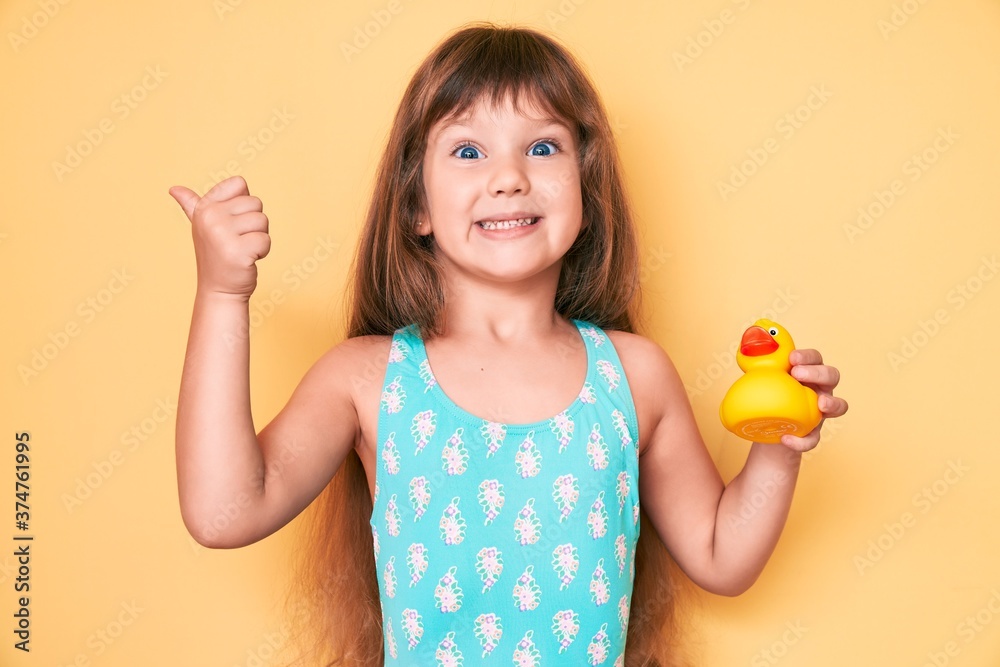 Little caucasian kid girl with long hair wearing swimsuit and holding ...