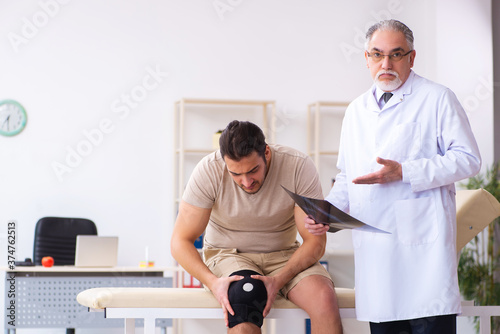 Experienced doctor radiologist examining young male patient