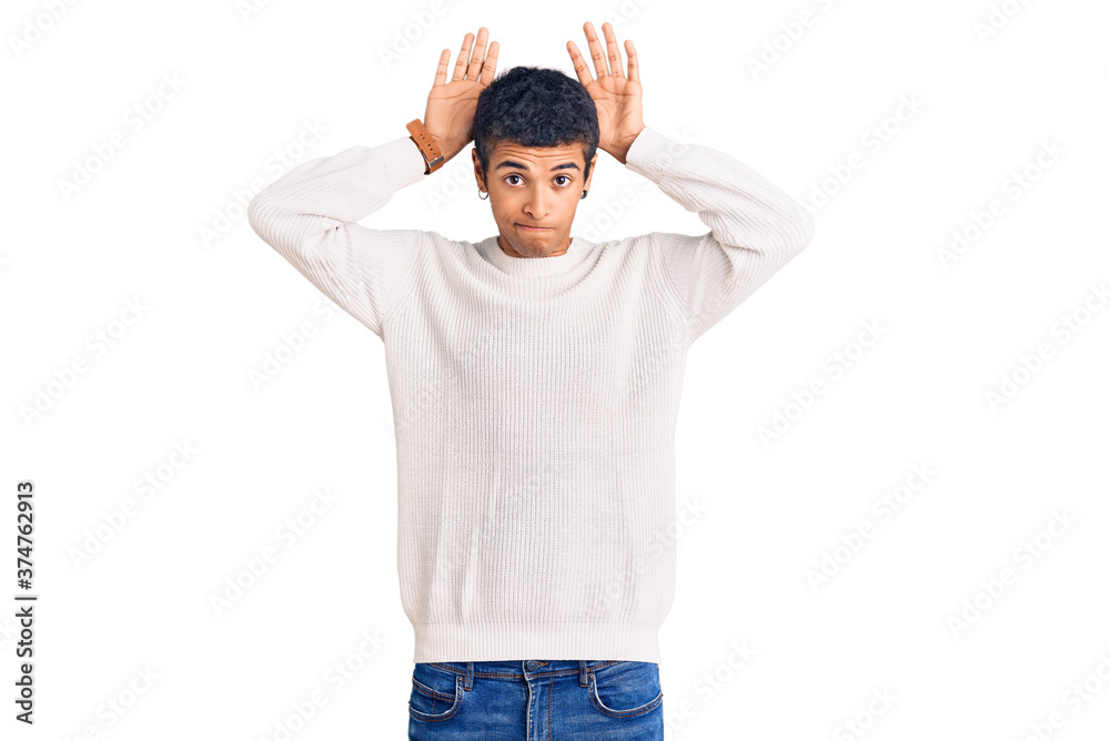 Young african amercian man wearing casual clothes doing bunny ears gesture with hands palms looking cynical and skeptical. easter rabbit concept.