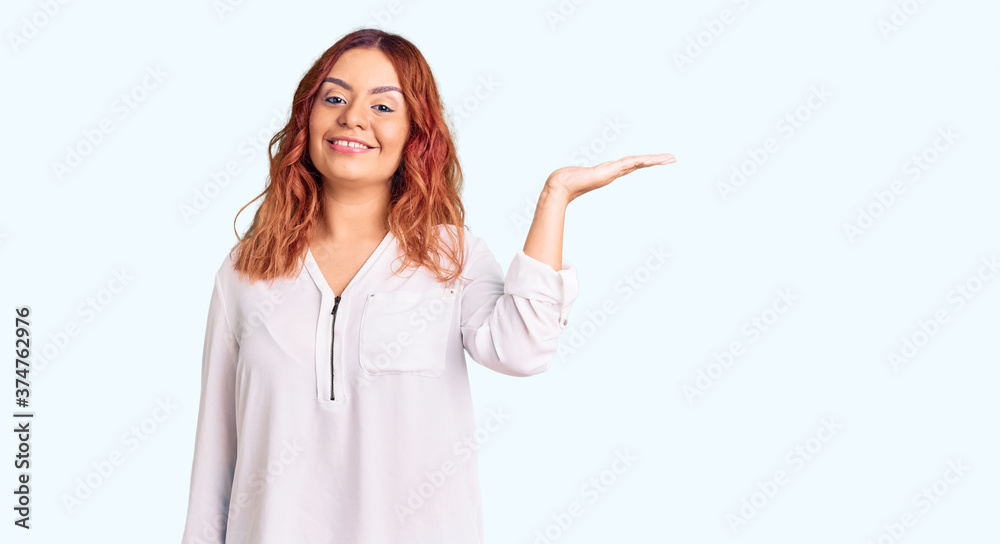 Young latin woman wearing casual clothes smiling cheerful presenting and pointing with palm of hand looking at the camera. Young latin woman wearing casual clothes smiling cheerful presenting and pointing with palm of hand looking at the camera.