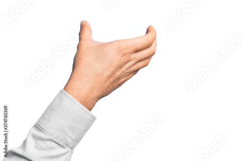 Hand of caucasian young man showing fingers over isolated white background holding invisible object, empty hand doing clipping and grabbing gesture