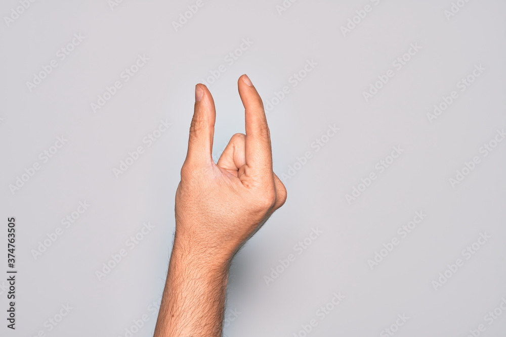 Hand of caucasian young man showing fingers over isolated white background picking and taking invisible thing, holding object with fingers showing space Hand of caucasian young man showing fingers over isolated white background picking and taking invisible thing, holding object with fingers showing space