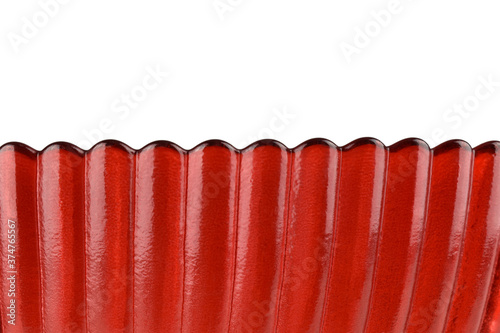 macro photo of red glass isolated on white background, close-up view of beautiful wavy edge glass, abstract background