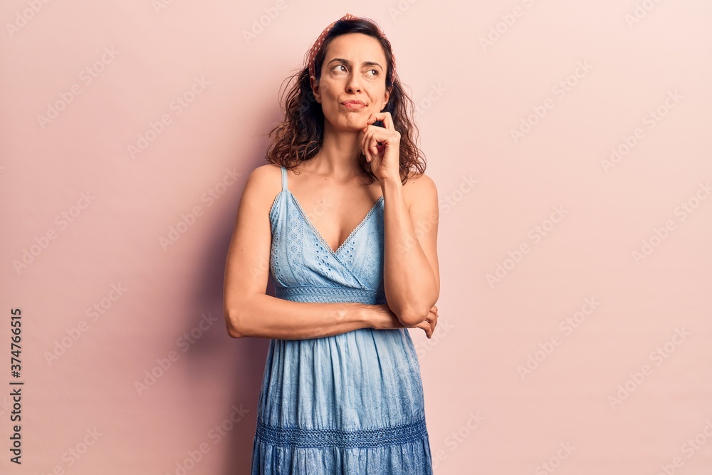 Young beautiful hispanic woman wearing casual dress and diadem thinking concentrated about doubt with finger on chin and looking up wondering Young beautiful hispanic woman wearing casual dress and diadem thinking concentrated about doubt with finger on chin and looking up wondering