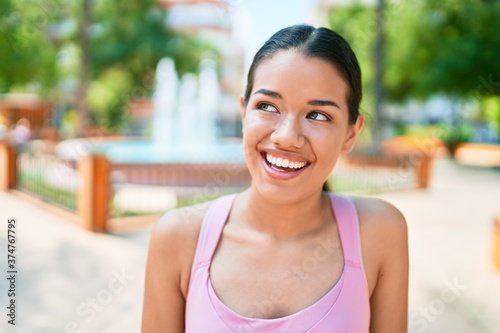 Young beautiful hispanic sporty woman wearing fitness outfit smiling happy and natural at the town Free Download Young beautiful hispanic sporty woman wearing fitness outfit smiling happy and natural at the town - GFXLoad