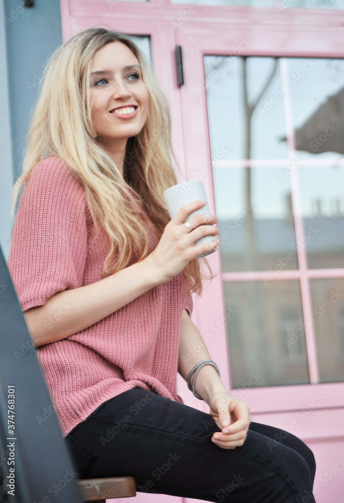 Beautiful woman with cup of hot drink outdoors. Autumn concept.