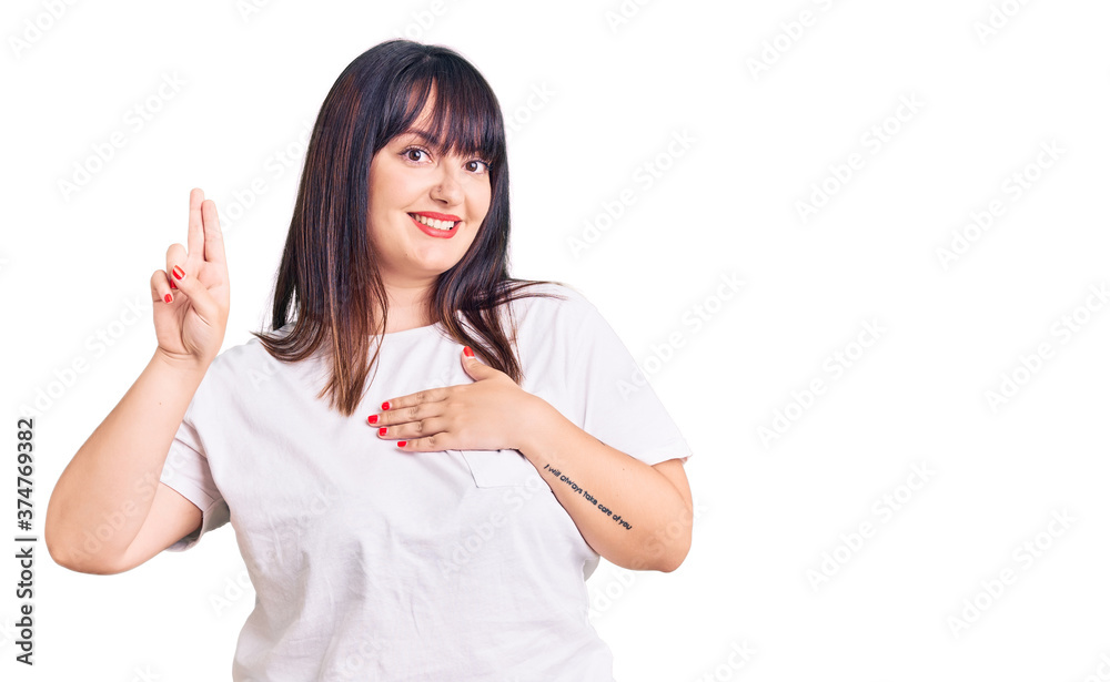 Young plus size woman wearing casual clothes smiling swearing with hand on chest and fingers up, making a loyalty promise oath