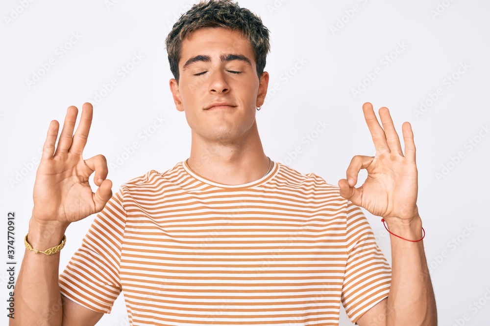 Young handsome man wearing casual clothes relax and smiling with eyes closed doing meditation gesture with fingers. yoga concept. Young handsome man wearing casual clothes relax and smiling with eyes closed doing meditation gesture with fingers. yoga concept.