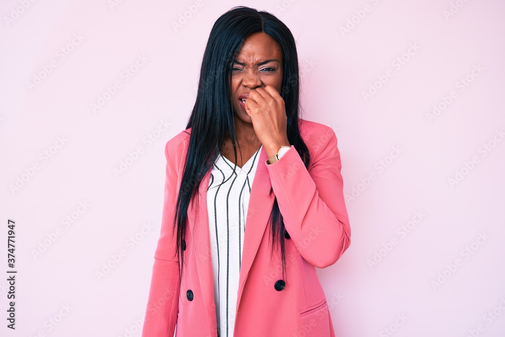 Young african american woman wearing business clothes looking stressed and nervous with hands on mouth biting nails. anxiety problem.