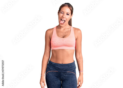 Young beautiful hispanic woman wearing sportswear winking looking at the camera with sexy expression  cheerful and happy face.