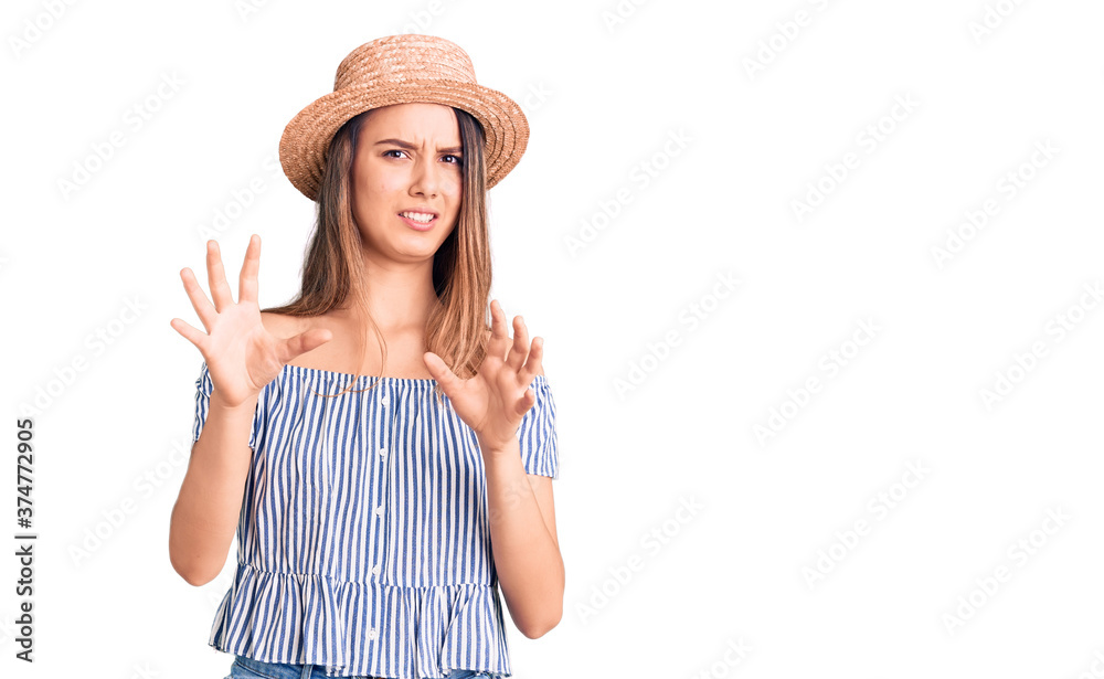 Young beautiful girl wearing hat and t shirt disgusted expression, displeased and fearful doing disgust face because aversion reaction. with hands raised Young beautiful girl wearing hat and t shirt disgusted expression, displeased and fearful doing disgust face because aversion reaction. with hands raised