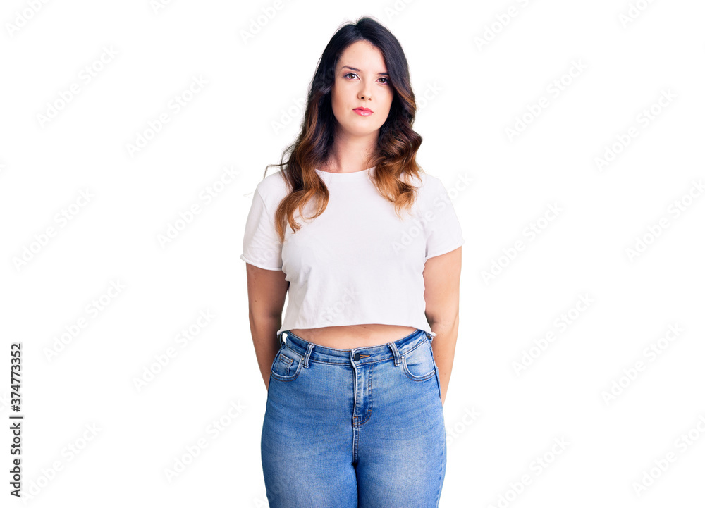 Obraz premium Beautiful young brunette woman wearing casual clothes with serious expression on face. simple and natural looking at the camera.
