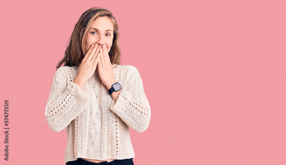 Young beautiful blonde woman wearing casual sweater laughing and embarrassed giggle covering mouth with hands, gossip and scandal concept Young beautiful blonde woman wearing casual sweater laughing and embarrassed giggle covering mouth with hands, gossip and scandal concept