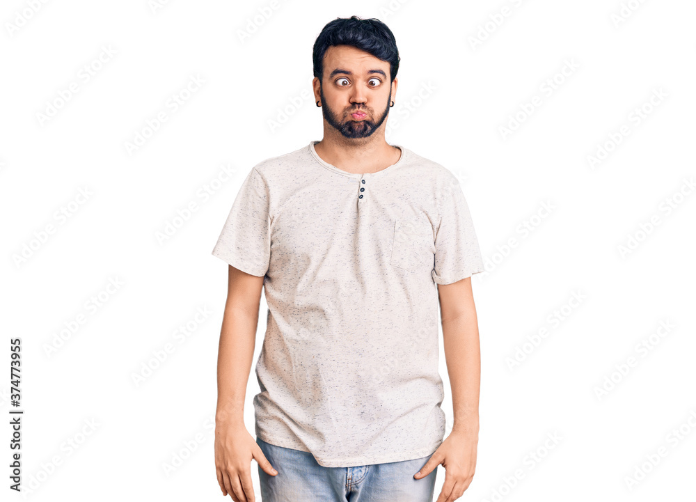 Young hispanic man wearing casual clothes making fish face with lips, crazy and comical gesture. funny expression. Young hispanic man wearing casual clothes making fish face with lips, crazy and comical gesture. funny expression.