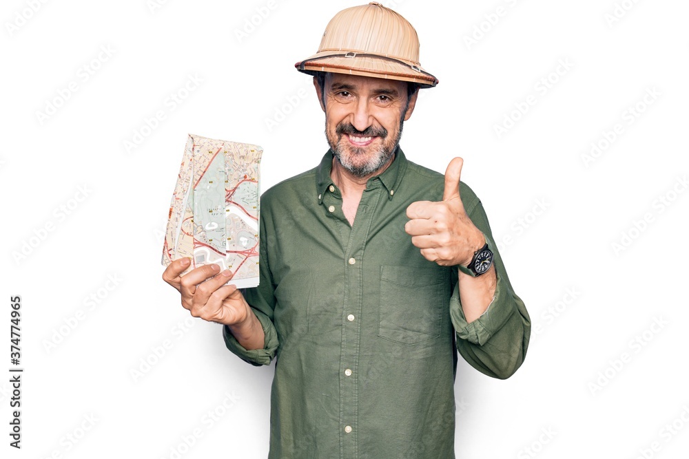 Middle age handsome tourist man on vacation wearing explorer hat holding city map smiling happy and positive, thumb up doing excellent and approval sign Middle age handsome tourist man on vacation wearing explorer hat holding city map smiling happy and positive, thumb up doing excellent and approval sign