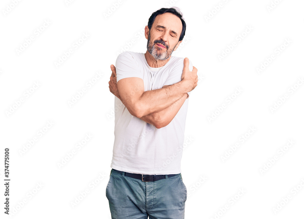 Middle age handsome man wearing casual t-shirt hugging oneself happy and positive, smiling confident. self love and self care Middle age handsome man wearing casual t-shirt hugging oneself happy and positive, smiling confident. self love and self care