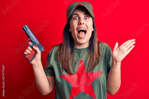 Billede på lærred Young beautiful brunette woman wearing t-shirt with red star communist symbol ho