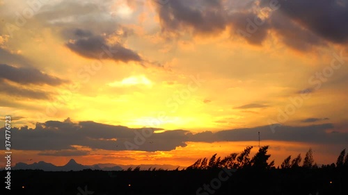 Beautiful orange sky and sunset over the mountains, Birds flying and the wind blowing,  Nature scenery landscape background.